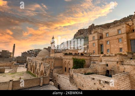 Blick auf die Altstadt von Mardin mit Schloss Mardin oben, Stadtbild von Mardin in der Türkei mit Sonnenuntergang am Himmel Stockfoto