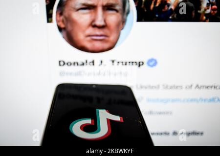 TikTok Nahauflauflogo auf einem Smartphone-Bildschirm und der Twitter-Feed des US-Präsidenten Donald Trump als Hintergrund auf einem TV-Bildschirm in Chania, Kreta, Griechenland am 3. August 2020. US-Präsident Donald Trump droht und plant, die beliebte Video-Sharing-App TikTok aus den USA wegen des Sicherheitsrisikos zu verbieten. (Foto von Nikolas Kokovlis/NurPhoto) Stockfoto