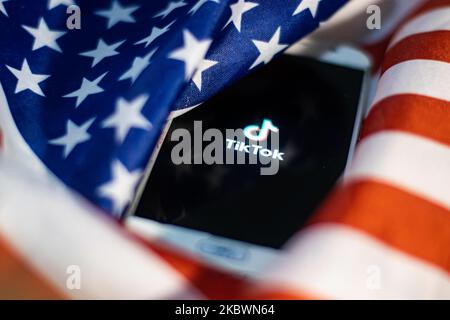 Das TikTok-Nahauffaltslogo, das auf einem Telefonbildschirm angezeigt wird, das Smartphone auf der amerikanischen oder US-amerikanischen Flagge, die Nationalflagge der Vereinigten Staaten, sind in dieser Abbildung mit mehreren Belichtungen zu sehen. TIK Tok ist ein chinesischer Social-Networking-Service, der sich im Besitz des in Peking ansässigen Internet-Technologie-Unternehmens Bytedance befindet. Es wird verwendet, um kurze Tanz-, Lip-Sync-, Comedy- und Talentvideos zu erstellen. Bytedance startete die TikTok App für iOS und Android im Jahr 2017 und Anfang September 2016 Douyin auf dem Markt in China. Im Oktober 2018 wurde TikTok zur am häufigsten heruntergeladenen App in den USA. Präsident der USA Donald Trump i. Stockfoto