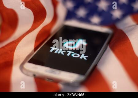 Das TikTok-Nahauffaltslogo, das auf einem Telefonbildschirm angezeigt wird, das Smartphone auf der amerikanischen oder US-amerikanischen Flagge, die Nationalflagge der Vereinigten Staaten, sind in dieser Abbildung mit mehreren Belichtungen zu sehen. TIK Tok ist ein chinesischer Social-Networking-Service, der sich im Besitz des in Peking ansässigen Internet-Technologie-Unternehmens Bytedance befindet. Es wird verwendet, um kurze Tanz-, Lip-Sync-, Comedy- und Talentvideos zu erstellen. Bytedance startete die TikTok App für iOS und Android im Jahr 2017 und Anfang September 2016 Douyin auf dem Markt in China. Im Oktober 2018 wurde TikTok zur am häufigsten heruntergeladenen App in den USA. Präsident der USA Donald Trump i. Stockfoto