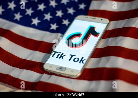 Das TikTok-Nahauffaltslogo, das auf einem Telefonbildschirm angezeigt wird, das Smartphone auf der amerikanischen oder US-amerikanischen Flagge, die Nationalflagge der Vereinigten Staaten, sind in dieser Abbildung mit mehreren Belichtungen zu sehen. TIK Tok ist ein chinesischer Social-Networking-Service, der sich im Besitz des in Peking ansässigen Internet-Technologie-Unternehmens Bytedance befindet. Es wird verwendet, um kurze Tanz-, Lip-Sync-, Comedy- und Talentvideos zu erstellen. Bytedance startete die TikTok App für iOS und Android im Jahr 2017 und Anfang September 2016 Douyin auf dem Markt in China. Im Oktober 2018 wurde TikTok zur am häufigsten heruntergeladenen App in den USA. Präsident der USA Donald Trump i. Stockfoto