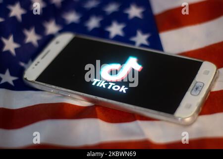 Das TikTok-Nahauffaltslogo, das auf einem Telefonbildschirm angezeigt wird, das Smartphone auf der amerikanischen oder US-amerikanischen Flagge, die Nationalflagge der Vereinigten Staaten, sind in dieser Abbildung mit mehreren Belichtungen zu sehen. TIK Tok ist ein chinesischer Social-Networking-Service, der sich im Besitz des in Peking ansässigen Internet-Technologie-Unternehmens Bytedance befindet. Es wird verwendet, um kurze Tanz-, Lip-Sync-, Comedy- und Talentvideos zu erstellen. Bytedance startete die TikTok App für iOS und Android im Jahr 2017 und Anfang September 2016 Douyin auf dem Markt in China. Im Oktober 2018 wurde TikTok zur am häufigsten heruntergeladenen App in den USA. Präsident der USA Donald Trump i. Stockfoto