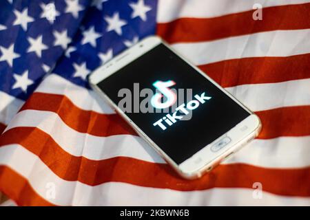 Das TikTok-Nahauffaltslogo, das auf einem Telefonbildschirm angezeigt wird, das Smartphone auf der amerikanischen oder US-amerikanischen Flagge, die Nationalflagge der Vereinigten Staaten, sind in dieser Abbildung mit mehreren Belichtungen zu sehen. TIK Tok ist ein chinesischer Social-Networking-Service, der sich im Besitz des in Peking ansässigen Internet-Technologie-Unternehmens Bytedance befindet. Es wird verwendet, um kurze Tanz-, Lip-Sync-, Comedy- und Talentvideos zu erstellen. Bytedance startete die TikTok App für iOS und Android im Jahr 2017 und Anfang September 2016 Douyin auf dem Markt in China. Im Oktober 2018 wurde TikTok zur am häufigsten heruntergeladenen App in den USA. Präsident der USA Donald Trump i. Stockfoto