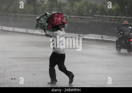 Ein Mann, der Güter transportiert, fährt am 05. August 2020 während der heftigen Regenfälle in Mumbai, Indien, über die Straße. (Foto von Himanshu Bhatt/NurPhoto) Stockfoto