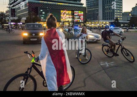 Protestierende mit einer alten belarussischen Flagge, Symbol des Widerstands gegen die Regierung, bevor sie am 7. August 2020 bei einer Fahrraddemonstration durch die Straßen von Minsk, Weißrussland, von der Polizei verhaftet wurde und während der Präsidentschaftswahlen in Belarus Regierungsreformen anforderten. (Foto von Celestino Arce/NurPhoto) Stockfoto