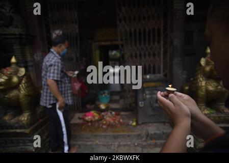 Ein nepalesischer Anhänger, der am Samstag, den 08. August 2020, auf dem Gelände des Bagh Bhairab Temple in Kirtipur, Kathmandu, Nepal, eine Butterlampe anbietet. (Foto von Narayan Maharjan/NurPhoto) Stockfoto