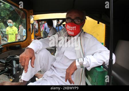 Ein Autofahrer bedeckt sein Gesicht mit einer Maske, die als Vorsichtsmaßnahme gegen Covid-19 am Connaught Place in der Hauptstadt Neu-Delhi, Indien, am 9. August 2020 aufgedruckt ist. Während der Grenzkonflikt entlang der Kontrolllinie (Line of Control, LAC) mit China weiter wütet, haben die Menschen in Indien beschlossen, chinesische Waren zu boykottieren. (Foto von Mayank Makhija/NurPhoto) Stockfoto