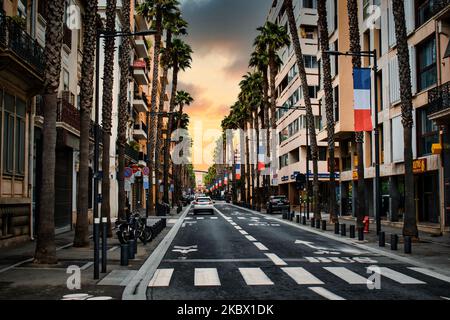 Eine wunderschöne urbane Szene einer Straße mit Palmen bei Sonnenuntergang Stockfoto