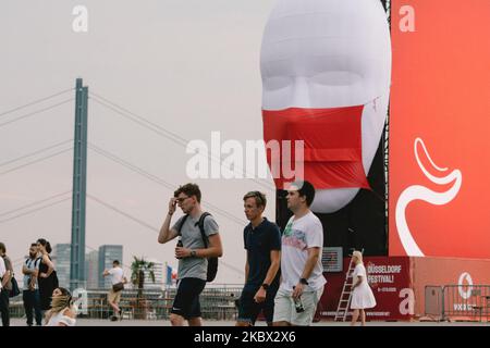 Die Menschen kommen an der Videokunst-Installation 'Faces of Duesseldorf' in Düsseldorf, Deutschland, am 13. August 2020 vorbei. (Foto von Ying Tang/NurPhoto) Stockfoto