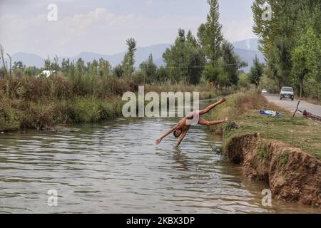 Kashmiri-Jungen kühlen sich an einem heißen Sommertag in der Stadt Sopore im Distrikt Baramulla, etwa 60Kms von Srinagar in Jammu und Kaschmir, Indien, am 13. August 2020 in einem Strom ab, um die Hitze zu schlagen. Srinagar verzeichnet 35,4 Grad celsius; das Wetter bleibt die nächste Woche heiß und feucht (Foto: Nasir Kachroo/NurPhoto) Stockfoto