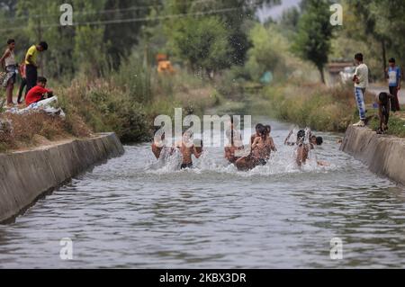 Kashmiri-Jungen kühlen sich an einem heißen Sommertag in der Stadt Sopore im Distrikt Baramulla, etwa 60Kms von Srinagar in Jammu und Kaschmir, Indien, am 13. August 2020 in einem Strom ab, um die Hitze zu schlagen. Srinagar verzeichnet 35,4 Grad celsius; das Wetter bleibt die nächste Woche heiß und feucht (Foto: Nasir Kachroo/NurPhoto) Stockfoto