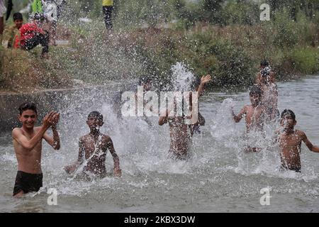 Kashmiri-Jungen kühlen sich an einem heißen Sommertag in der Stadt Sopore im Distrikt Baramulla, etwa 60Kms von Srinagar in Jammu und Kaschmir, Indien, am 13. August 2020 in einem Strom ab, um die Hitze zu schlagen. Srinagar verzeichnet 35,4 Grad celsius; das Wetter bleibt die nächste Woche heiß und feucht (Foto: Nasir Kachroo/NurPhoto) Stockfoto