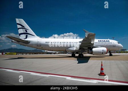 Ein Airbus A320 mit Zulassung SX-DGX parkte mit den abgedeckten Motoren. Die geerdete Passagierflotte der Airbus-A320-Familie von Aegean Airlines, die am internationalen Flughafen Athen ATH LGAV in der griechischen Hauptstadt abgestellt wurde. Aegean Airlines ist die unter der Flagge Griechenlands ansässige Fluggesellschaft mit Sitz in Athen. Die Flugzeuge fliegen aufgrund des Ausbruchs der Covid-Pandemie nicht. Viele der Flugzeuge haben ihre Triebwerke mit einer roten Abdeckung bedeckt. Covid-19-Fälle explodieren in Griechenland in den letzten Tagen, da Touristen und Einheimische entspannter sind, ohne die sozialen Distanzierungen und obligatorischen Sicherheitsmaßnahmen zu halten Stockfoto