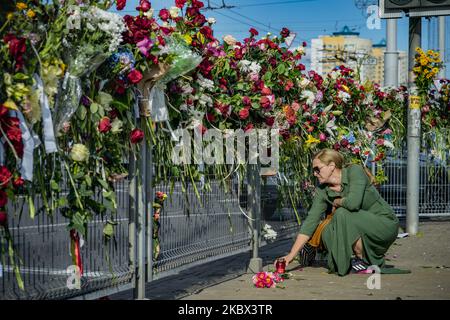 Eine Frau setzt eine Kerze in ein blühtes Denkmal, in dem ein Mann bei Zusammenstößen zwischen Polizeiaufstand und Menschen während eines Protestes in Minsk gegen das behauptete betrügerische Ergebnis der Präsidentschaftswahlen in Belarus getötet wurde. Am 11. August 2020 in Minsk, Weißrussland. (Foto von Celestino Arce/NurPhoto) Stockfoto