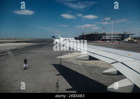 Ein männlicher Passagier mit Gesichtsmast, der zum Flugzeug zu Fuß geht. Fliegen in einem Aegean Airlines Airbus A320 während der Coronavirus-Pandemie mit obligatorischer Verwendung von Gesichtsmasken für die Passagiere im Flugzeug und am Flughafen. Die Flugbesatzung, die weibliche Flugbegleiterin, trägt auch Sicherheitsausrüstung wie Gesichtsmasken und Handschuhe, während die Mahlzeiten gewechselt werden und eine desinfizierende Serviette bereitgestellt wird. Die Inlandsflugroute ist von Thessaloniki SKG LGTS zum Athens ATH LGAV Airport, der griechischen Hauptstadt. Die griechische Regierung hob das Verkehrsverbot auf, sperrte Quarantänemaßnahmen für Touristen, eas Stockfoto