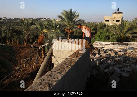 Ein Palästinenser inspiziert nach einem israelischen Luftangriff östlich des Al-Bureij-Lagers für palästinensische Flüchtlinge im zentralen Gazastreifen am 15. August 2020 Schutt und andere Schäden auf einem Dach. (Foto von Majdi Fathi/NurPhoto) Stockfoto