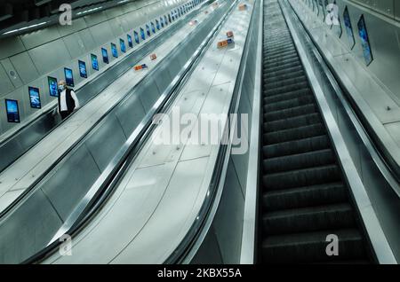 Ein Mann mit Gesichtsmaske fährt am 14. August 2020 in einer nahe verlassenen Station in der Tottenham Court Road in London, England, eine Rolltreppe hinab. Die Passagierzahlen in der Londoner U-Bahn bleiben deutlich unter dem Niveau vor der Pandemie, da die Stadt weiterhin zögerlich nach der Blockierung des Coronavirus aufbricht, wobei die Befürchtungen von Covid-19 viele immer noch von der Nutzung öffentlicher Verkehrsmittel abhält. (Foto von David Cliff/NurPhoto) Stockfoto