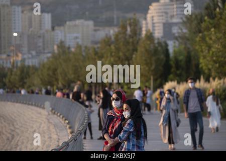 Zwei iranische Frauen, die Schutzmasken tragen, stehen nach dem Ausbruch der COVID-19 im Iran am 13. August 2020 im künstlichen See-Komplex Chitgar im Nordwesten Teherans. Die Menschen in Teheran scheinen sich an das neue Coronavirus gewöhnt zu haben und verwenden die Maske als tägliche Routine. (Foto von Morteza Nikoubazl/NurPhoto) Stockfoto