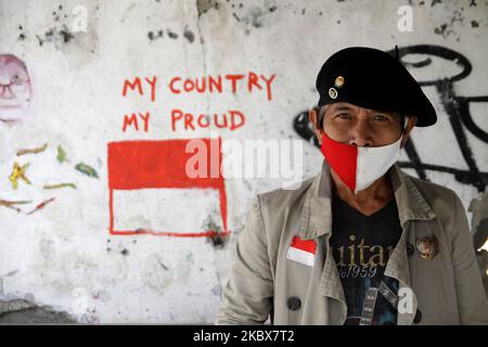 Der indonesische Straßenkünstler Bambang (63) trägt eine Gesichtsmaske in indonesischer Nationalflaggenfarbe und ist während des indonesischen Unabhängigkeitstages 75. in Jakarta am 17. August 2020 fotografisch mit indonesischer Nationalflaggenfarbe als Hintergrund dargestellt. In diesem Jahr feiern die Indonesier ihren Unabhängigkeitstag auf die Art und Weise der Diferenz, da die Regierung der Öffentlichkeit untersagt, wie üblich jegliche Feierlichkeiten, einschließlich Wettkampfspielen, durchzuführen, um die Ausbreitung des Covid-19-Coronavirus zu verhindern. (Foto von Aditya Irawan/NurPhoto) Stockfoto