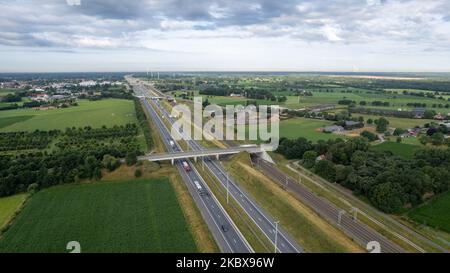 Brecht, Belgien, 6.. Juli 2022, Panorama-Drohnenansicht von Windpark oder Windpark, mit hohen Windkraftanlagen zur Stromerzeugung mit der Autobahn mit wenigen Autos und Eisenbahn daneben, in der Nähe der Ausfahrt von Brecht in Belgien, Europa. Hochwertige Fotos Stockfoto