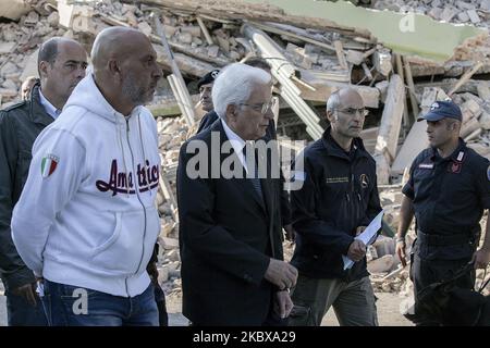 Italiens Präsident Sergio Mattarella (C) schaut zu, während er am 26. August 2016, drei Tage nach einem Erdbeben der Stärke 6,2 in der Region, neben dem Bürgermeister von Amurrice Sergio Pirozzi (L) in dem beschädigten zentralitalienischen Dorf Amurrice geht, bei dem rund 281 Menschen ums Leben kamen. (Foto von Paolo Manzo/NurPhoto) Stockfoto