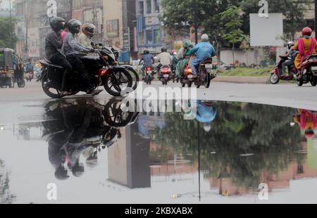 Pendler, Fahrzeuge und andere Fußgänger werden am 19. August 2020 in der Regenzeit in der Hauptstadt Bhubaneswar des ostindischen Staates Odisha auf der Straße gesehen. Nachdem die Back-to-Back-Niederdrucksysteme Teile von Odisha mit Sturzfluten konfrontiert haben, könnte die Prognose des indischen Meteorologischen Departements (IMD) für schwere Regenschauer in 12 Distrikten, die wahrscheinlich durch ein neues System über Bay Bengal verursacht werden, die Probleme des Staates noch weiter erhöhen. Das Wetterbüro am Dienstag hat bereits einen orangen Alarm ausgelöst. (Foto von STR/NurPhoto) Stockfoto