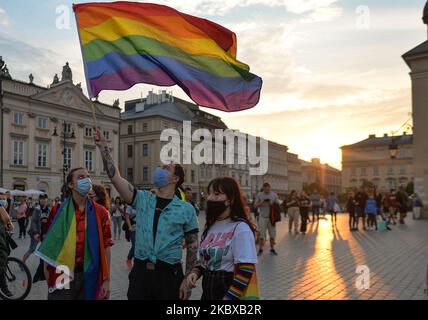 Ein Pro-LGBT-Protestler hält während des Protestes eine Regenbogenfahne. Rechtsextreme Nationalisten und Pro-Life-Aktivisten organisierten einen Protest gegen den LGBT neben dem Adam-Mickiewicz-Denkmal auf dem Krakauer Hauptmarkt. Auf der gegenüberliegenden Seite des Platzes organisierten LGBT-Aktivisten und Antifaschisten einen Gegenprotest. Am 19. August 2020 in Krakau, Woiwodschaft Kleinpolen, Polen. (Foto von Artur Widak/NurPhoto) Stockfoto