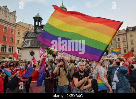 Ein Pro-LGBT-Protestler hält während des Protestes eine Regenbogenfahne. Rechtsextreme Nationalisten und Pro-Life-Aktivisten organisierten einen Protest gegen den LGBT neben dem Adam-Mickiewicz-Denkmal auf dem Krakauer Hauptmarkt. Auf der gegenüberliegenden Seite des Platzes organisierten LGBT-Aktivisten und Antifaschisten einen Gegenprotest. Am 19. August 2020 in Krakau, Woiwodschaft Kleinpolen, Polen. (Foto von Artur Widak/NurPhoto) Stockfoto