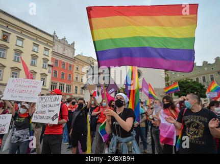 Ein Pro-LGBT-Protestler hält während des Protestes eine Regenbogenfahne. Rechtsextreme Nationalisten und Pro-Life-Aktivisten organisierten einen Protest gegen den LGBT neben dem Adam-Mickiewicz-Denkmal auf dem Krakauer Hauptmarkt. Auf der gegenüberliegenden Seite des Platzes organisierten LGBT-Aktivisten und Antifaschisten einen Gegenprotest. Am 19. August 2020 in Krakau, Woiwodschaft Kleinpolen, Polen. (Foto von Artur Widak/NurPhoto) Stockfoto