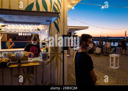 Die Jungs arbeiten am 21. August 2020 in einem Pub in der Nähe des Hafens von Molfetta, Italien, und tragen nach 6,00 Uhr Masken in Molfetta, Italien. Aufgrund der Zunahme der mit dem Covid-19-Virus infizierten Fälle in Italien und Apulien hat der Bürgermeister von Molfetta, Italien, die Pflicht zum Tragen einer Maske in Molfetta, Italien, von 18,00 bis 6,00, insbesondere in Gebieten der Stadt mit einer größeren Überfüllung von Menschen, In Korrespondenz mit Sehenswürdigkeiten und Spaziergängen und Clubs und Pubs. (Foto von Davide Pischettola/NurPhoto) Stockfoto