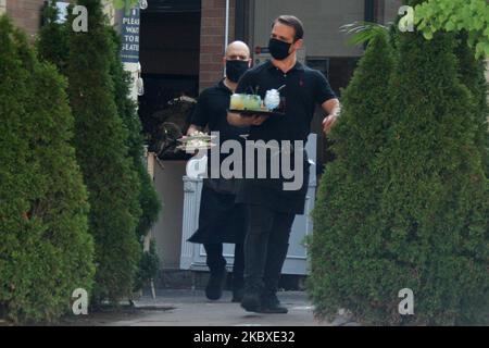 Kellner, die Gesichtsmasken tragen, um sie vor dem neuartigen Coronavirus (COVID-19) zu schützen, während sie am 21. August 2020 Teller mit Lebensmitteln auf einer Restaurantterrasse in Toronto, Ontario, Kanada, zu den Gästen trugen. (Foto von Creative Touch Imaging Ltd./NurPhoto) Stockfoto