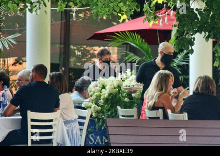 Kellner, die Gesichtsmasken tragen, um sie vor dem neuartigen Coronavirus (COVID-19) zu schützen, während sie am 21. August 2020 auf einer Restaurantterrasse in Toronto, Ontario, Kanada, den Gästen dienen. (Foto von Creative Touch Imaging Ltd./NurPhoto) Stockfoto