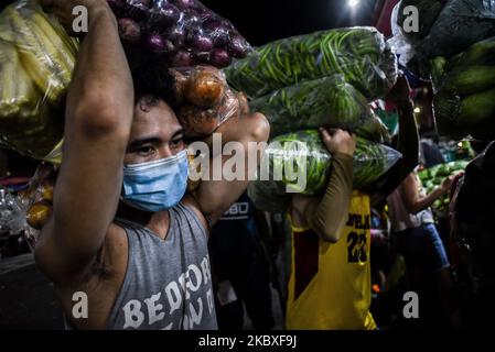 Am 23. August 2020 transportieren Arbeiter Gemüse auf einem öffentlichen Markt in Manila, Philippinen. Die Gesamtzahl der COVID-19-Fälle auf den Philippinen stieg auf 189.601, nachdem 2.378 neue Fälle registriert wurden. (Foto: Lisa Marie David/NurPhoto) Stockfoto