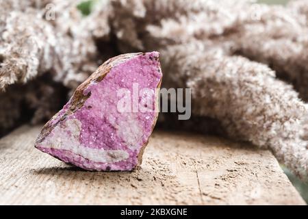 Kobaltoan Calcit Pink Crystals Cluster. Sphalocobaltit Kobaltkarbonat Mineralstein über natürlichem Holzhintergrund Stockfoto