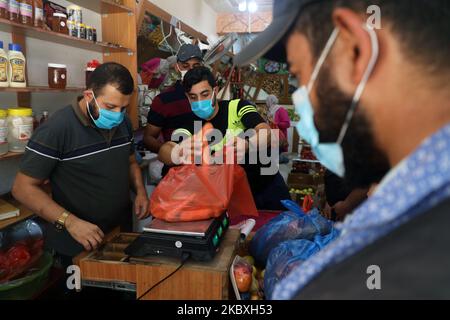 Palästinenser versammeln sich in einem Geschäft während einer 48-stündigen Sperre, die nach der Entdeckung der ersten Coronavirus-Fälle im Gazastreifen am Dienstag, den 25. August 2020, verhängt wurde. (Foto von Majdi Fathi/NurPhoto) Stockfoto