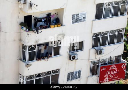 Palästinenser blicken von ihrem Balkon während einer 48-stündigen Sperre, die nach der Entdeckung der ersten Coronavirus-Fälle im Gazastreifen, Dienstag, den 25. August 2020, verhängt wurde. (Foto von Majdi Fathi/NurPhoto) Stockfoto