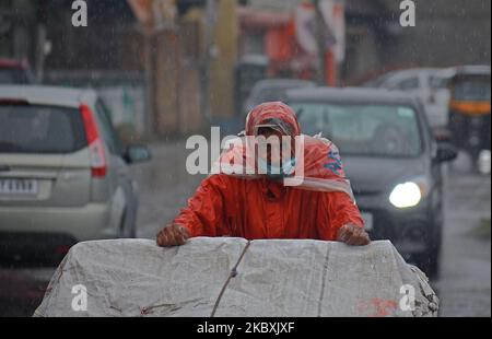 Ein Mann zieht am 26. August 2020 in Srinagar, Kaschmir, Indien, einen Handwagen. Regen schlug Teile von Jammu und Kaschmir, was den Menschen Ruhe gab und einen langen trockenen Zauber über das Tal beendete. (Foto von Faisal Khan/NurPhoto) Stockfoto