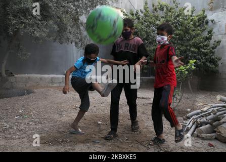 Jungen mit Gesichtsmasken spielen am 26. August 2020 in Gaza City, Palästina, mit einem Fußball. (Foto von Majdi Fathi/NurPhoto) Stockfoto