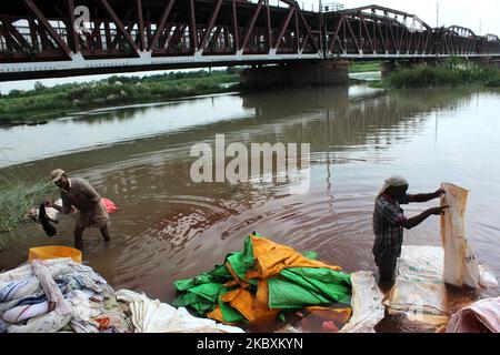 Am 27. August 2020 in Neu-Delhi, Indien, waschen Männer in der tief liegenden Gegend am Ufer des Flusses Yamuna unterhalb der Old Iron Bridge im Shastri Park ihre Kleidung. (Foto von Mayank Makhija/NurPhoto) Stockfoto