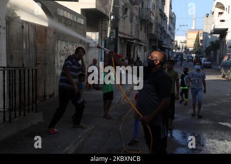 Ein palästinensischer Arbeiter sprüht Desinfektionsmittel auf einer Straße nach dem Ausbruch der Coronavirus-Krankheit (COVID-19), am 28. August 2020 in Gaza-Stadt. (Foto von Majdi Fathi/NurPhoto) Stockfoto