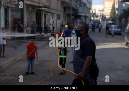 Ein palästinensischer Arbeiter sprüht Desinfektionsmittel auf einer Straße nach dem Ausbruch der Coronavirus-Krankheit (COVID-19), am 28. August 2020 in Gaza-Stadt. (Foto von Majdi Fathi/NurPhoto) Stockfoto