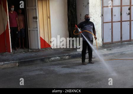 Ein palästinensischer Arbeiter sprüht Desinfektionsmittel auf einer Straße nach dem Ausbruch der Coronavirus-Krankheit (COVID-19), am 28. August 2020 in Gaza-Stadt. (Foto von Majdi Fathi/NurPhoto) Stockfoto