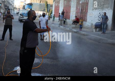 Ein palästinensischer Arbeiter sprüht Desinfektionsmittel auf einer Straße nach dem Ausbruch der Coronavirus-Krankheit (COVID-19), am 28. August 2020 in Gaza-Stadt. (Foto von Majdi Fathi/NurPhoto) Stockfoto