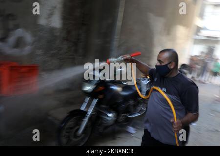 Ein palästinensischer Arbeiter sprüht Desinfektionsmittel auf einer Straße nach dem Ausbruch der Coronavirus-Krankheit (COVID-19), am 28. August 2020 in Gaza-Stadt. (Foto von Majdi Fathi/NurPhoto) Stockfoto