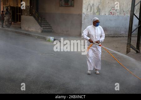 Ein palästinensischer Arbeiter sprüht Desinfektionsmittel auf einer Straße nach dem Ausbruch der Coronavirus-Krankheit (COVID-19), am 28. August 2020 in Gaza-Stadt. (Foto von Majdi Fathi/NurPhoto) Stockfoto