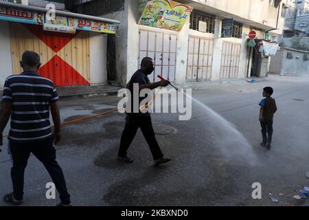 Ein palästinensischer Arbeiter sprüht Desinfektionsmittel auf einer Straße nach dem Ausbruch der Coronavirus-Krankheit (COVID-19), am 28. August 2020 in Gaza-Stadt. (Foto von Majdi Fathi/NurPhoto) Stockfoto