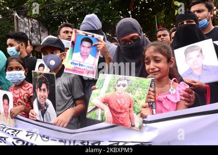 Verwandte halten Portraits ihrer vermissten Familienmitglieder, während sie vor dem Internationalen Tag der Verschwundenen im Shahbagh-Gebiet in Dhaka, Bangladesch, am 29. August 2020 eine Menschenkette bilden. Die Kundgebung der Menschenketten wird von der Plattform Mayer Daak (Mother's Call) organisiert. Nach Angaben der Rechtsrechtsvertretungsgruppe Ain O Salish Kendra (ASK) sind zwischen 2014 und 2018 mindestens 310 Menschen in Bangladesch verschwunden. Der Internationale Tag der Verschwundenen, wird am 30. August jedes Jahres begangen. (Foto von Mamunur Rashid/NurPhoto) Stockfoto