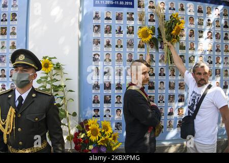 Ukrainer legen Blumen an die Gedenkmauer der gefallenen Verteidiger der Ukraine im Krieg in der Ostukraine 2014-2020 während einer Gedenkfeier zum Gedenktag der gefallenen Verteidiger der Ukraine in Kiew, Ukraine, 29. August 2020. (Foto von Maxym Marusenko/NurPhoto) Stockfoto