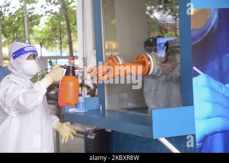 Gesundheitsfachkraft sprüht Desinfektionsmittel, nachdem ein Labortechniker inmitten der Coronavirus-Pandemie in Dhaka, Bangladesch, am 29. August 2020 eine Nasenabstrichprobe von einem Bewohner des Mugda Medical College and Hospital gesammelt hat (Foto: Mamunur Rashid/NurPhoto) Stockfoto