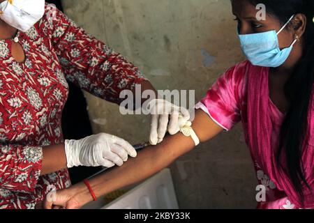 Ein Mitarbeiter im Gesundheitswesen nimmt eine Blutprobe von einer Person für die dritte Runde serologischer Vermessungstests auf Coronaviren am 3. September 2020 in einem Anganwadi-Zentrum in Vikram Nagar in der Nähe von ITO in Neu-Delhi, Indien, auf. Die Übung hilft der Verabreichung, Trends zu analysieren und Konzepte und Strategien zur Eindämmung der Infektion zu formulieren. (Foto von Mayank Makhija/NurPhoto) Stockfoto